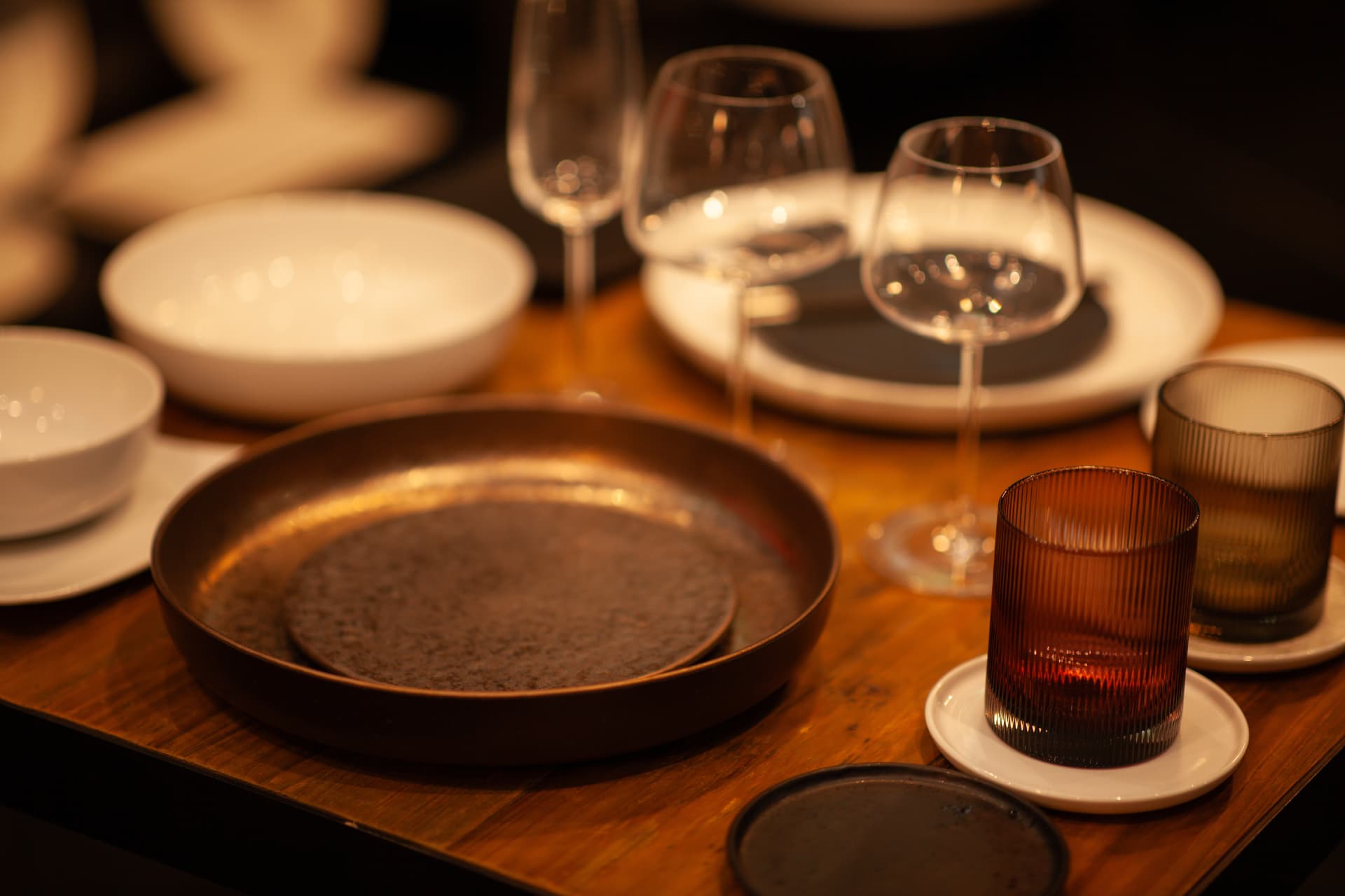 Candlelit table setting with wine glasses and ceramic plates